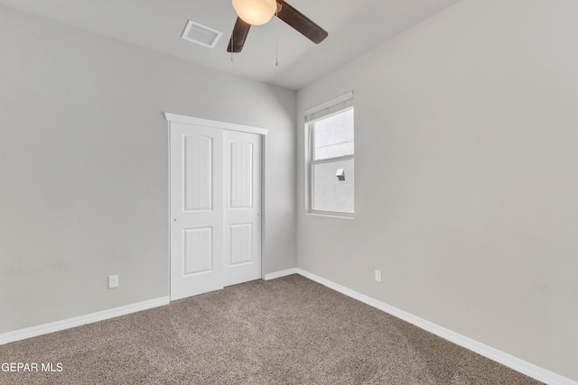 unfurnished bedroom with ceiling fan, carpet floors, and a closet