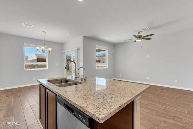 kitchen with dishwasher, a center island with sink, ceiling fan with notable chandelier, sink, and hanging light fixtures