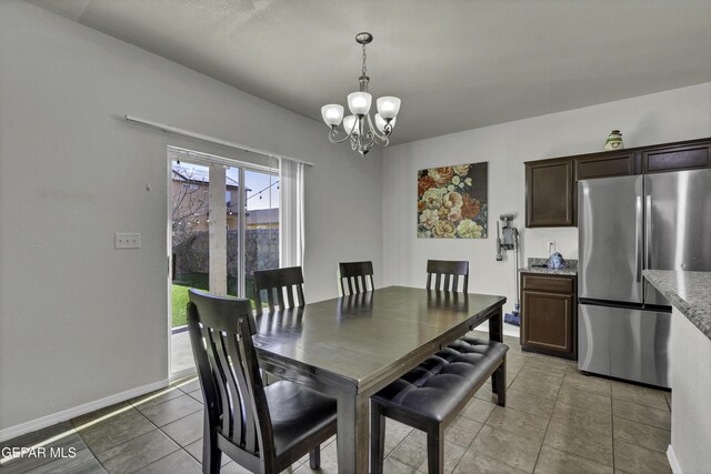 tiled dining room with an inviting chandelier