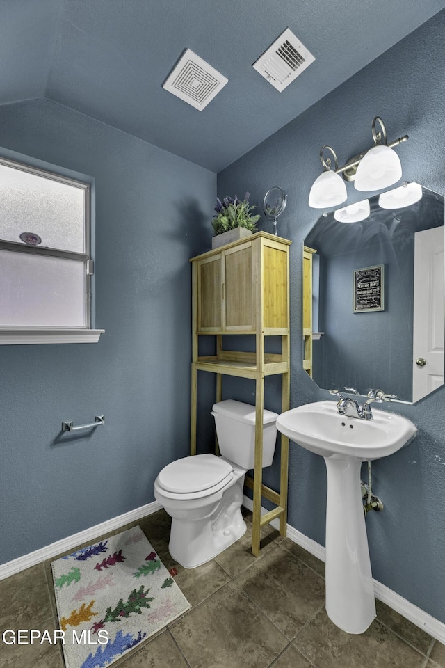 bathroom featuring vaulted ceiling and toilet