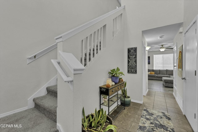 stairway featuring tile patterned floors and ceiling fan