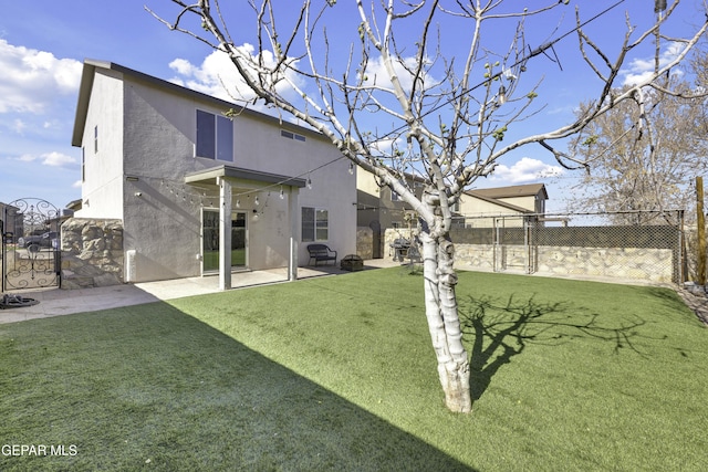 back of house with a yard and a patio