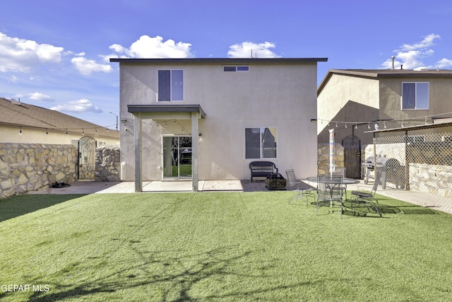 back of property with a yard and a patio