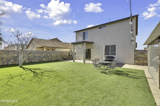 rear view of house featuring a yard and a patio