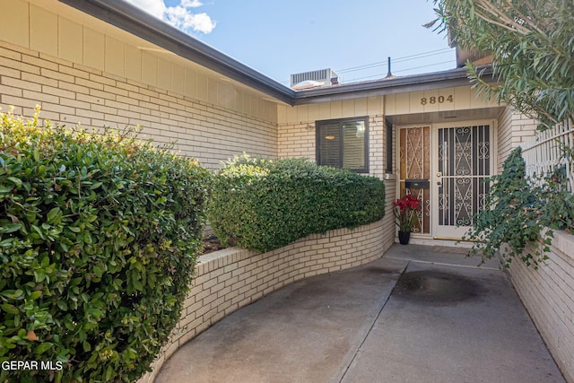 property entrance with a patio area and central AC unit