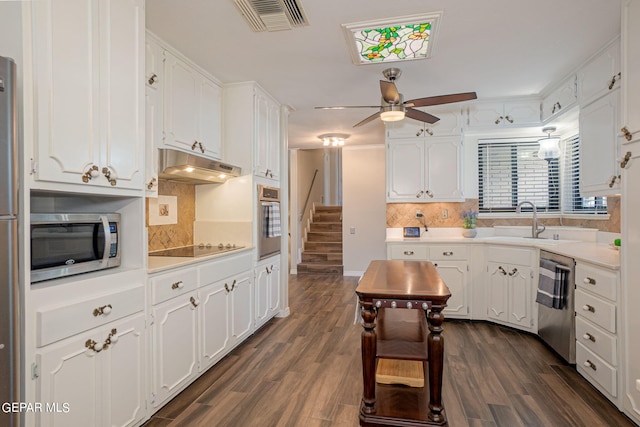 kitchen with decorative backsplash, white cabinets, dark hardwood / wood-style floors, and appliances with stainless steel finishes