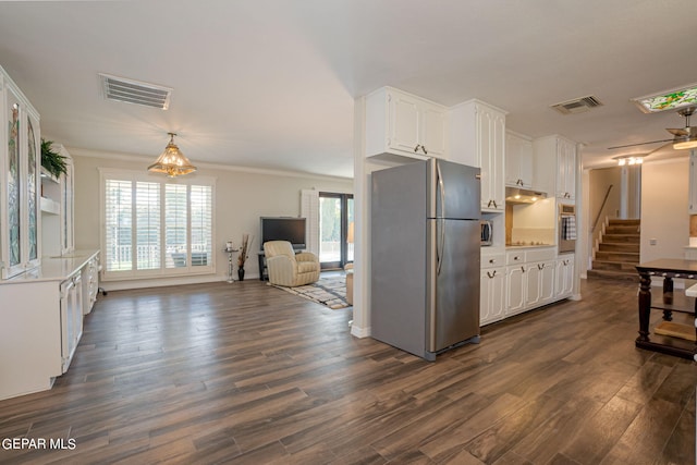 kitchen featuring dark hardwood / wood-style floors, white cabinetry, stainless steel appliances, and ornamental molding