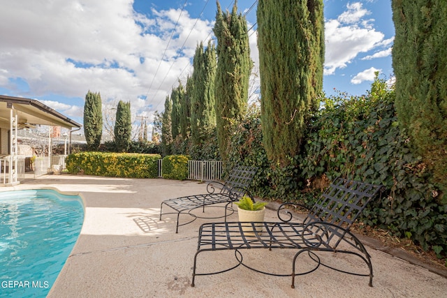 view of swimming pool featuring ceiling fan and a patio