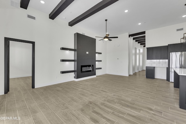 1762 Green Valley St, El Paso, TX 79928 - unfurnished living room with a ceiling fan, beam ceiling, light wood finished floors, recessed lighting, and a glass covered fireplace