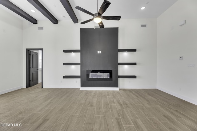 1762 Green Valley St, El Paso, TX 79928 - unfurnished living room featuring ceiling fan, a large fireplace, wood finished floors, beam ceiling, and baseboards