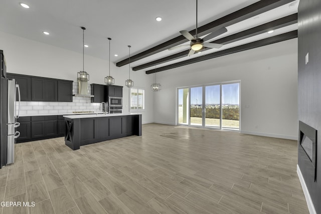 1762 Green Valley St, El Paso, TX 79928 - kitchen featuring open floor plan, stainless steel appliances, ceiling fan, beam ceiling, and wall chimney exhaust hood