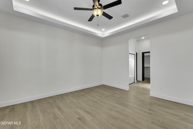 1762 Green Valley St, El Paso, TX 79928 - empty room with a tray ceiling, a ceiling fan, recessed lighting, light wood-style floors, and baseboards