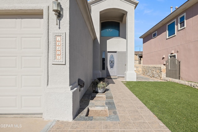 doorway to property with a yard and a garage