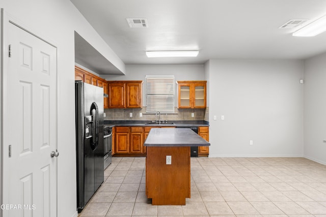 kitchen with black appliances, a center island, tasteful backsplash, light tile patterned floors, and sink