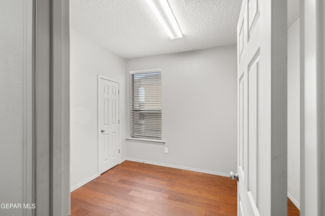 unfurnished bedroom with hardwood / wood-style floors and a textured ceiling