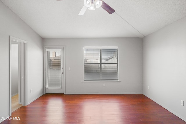 empty room featuring ceiling fan, a textured ceiling, and wood-type flooring