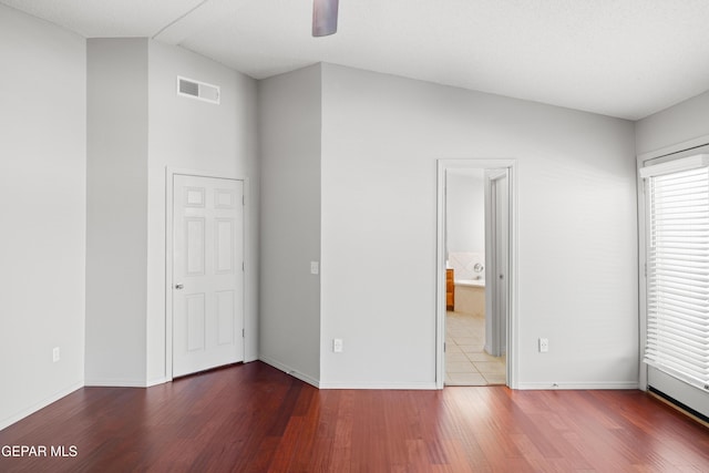 unfurnished bedroom featuring wood-type flooring, vaulted ceiling, and ceiling fan