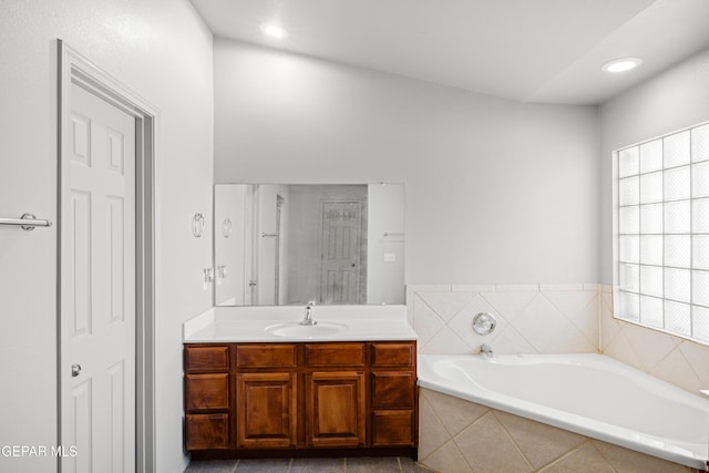 bathroom featuring vanity and a relaxing tiled tub