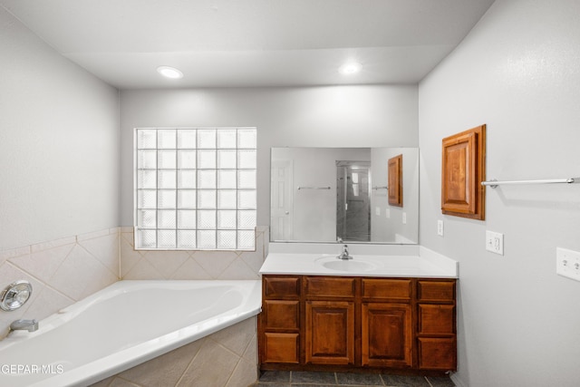 bathroom with vanity and tiled tub