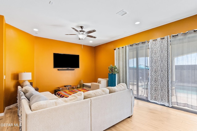 living room with ceiling fan and light hardwood / wood-style flooring