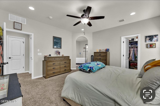 carpeted bedroom with a spacious closet, a closet, and ceiling fan