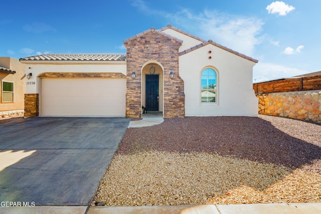 mediterranean / spanish home featuring a garage