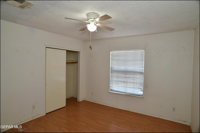 12560 Angie Bombach Ave, El Paso, TX 79928 - unfurnished bedroom with a textured ceiling, light wood-type flooring, a closet, and ceiling fan