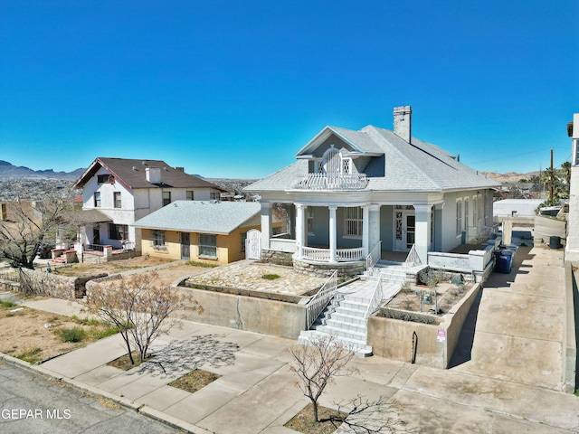 exterior space with a mountain view, a porch, and a balcony