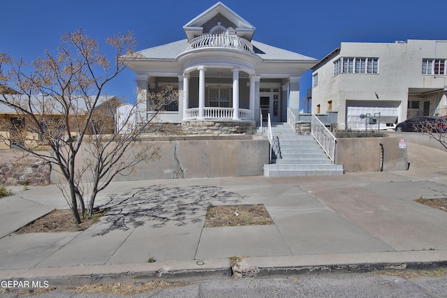 view of front of house with covered porch, a balcony, and a garage