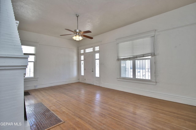 unfurnished living room featuring ceiling fan and wood-type flooring