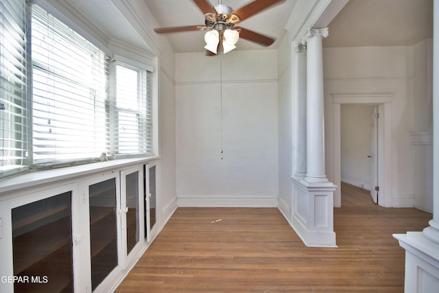 spare room with decorative columns, ceiling fan, and wood-type flooring