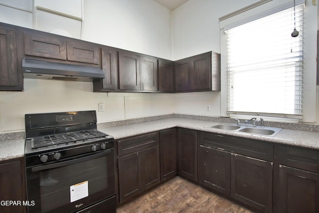 kitchen featuring a healthy amount of sunlight, sink, black gas range oven, and dark wood-type flooring