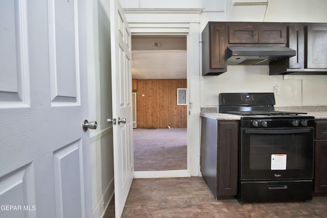 kitchen with dark brown cabinetry, black range, wooden walls, and range hood