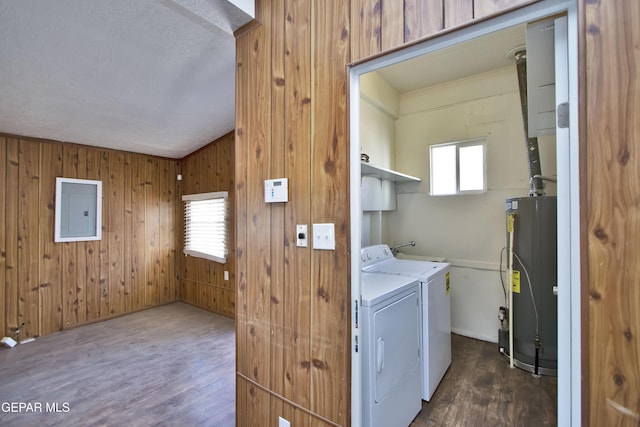 laundry room featuring electric panel, wooden walls, dark hardwood / wood-style floors, and gas water heater