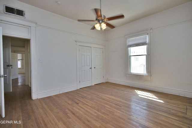 unfurnished bedroom featuring hardwood / wood-style flooring, ceiling fan, and a closet