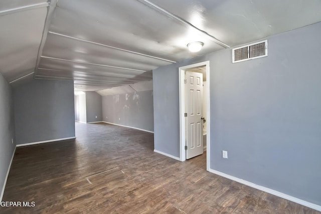 additional living space featuring dark hardwood / wood-style floors and lofted ceiling