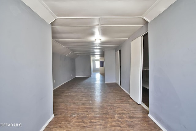 hallway featuring dark hardwood / wood-style flooring and lofted ceiling