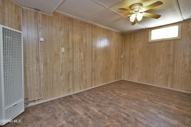 spare room featuring ceiling fan, hardwood / wood-style floors, and wood walls