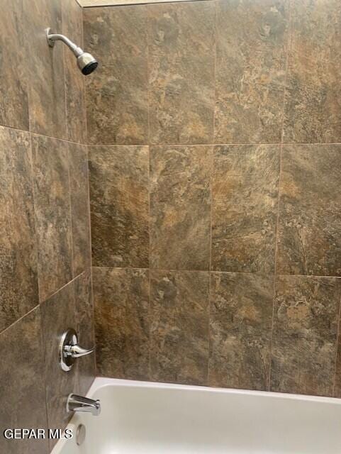 room details with tiled shower / bath combo