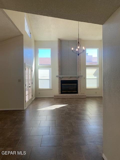 unfurnished living room with a notable chandelier and a fireplace