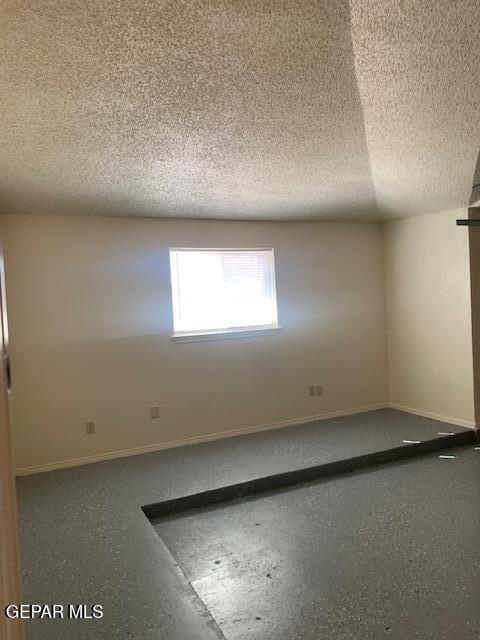 unfurnished room with a textured ceiling