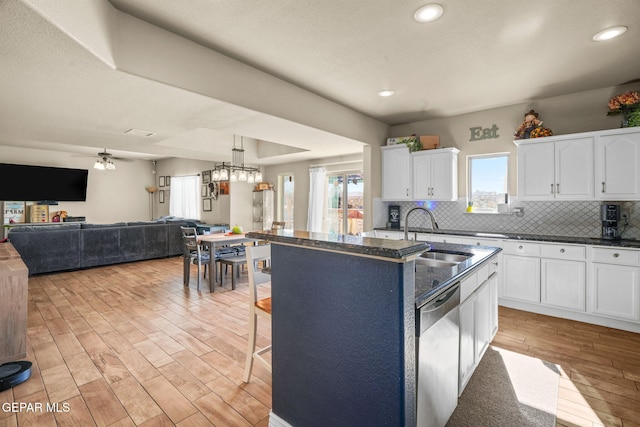 kitchen with white cabinetry, ceiling fan, dishwasher, sink, and an island with sink