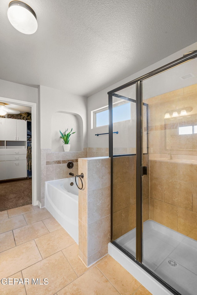 bathroom featuring tile patterned floors, a textured ceiling, and independent shower and bath