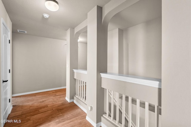 hallway with hardwood / wood-style floors and a textured ceiling