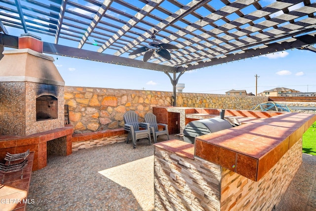 view of patio / terrace featuring a pergola, area for grilling, ceiling fan, and exterior kitchen