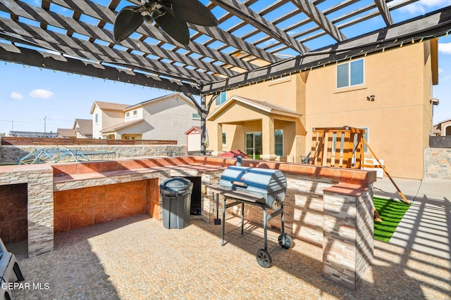 view of patio featuring a pergola, ceiling fan, and grilling area