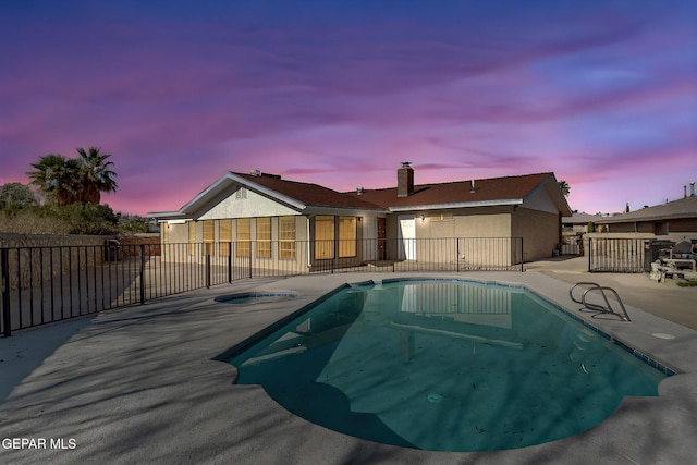 pool at dusk with a patio