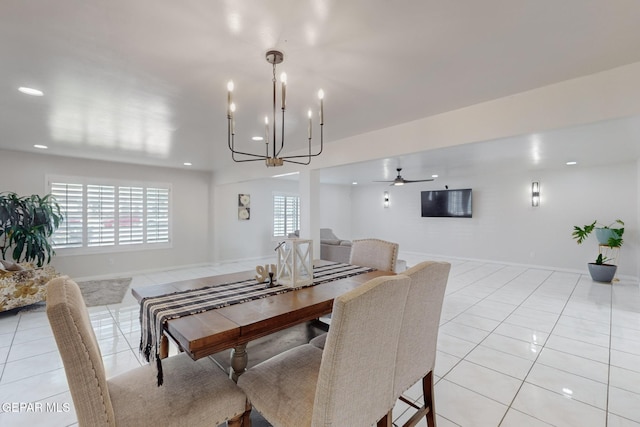 tiled dining area with ceiling fan with notable chandelier