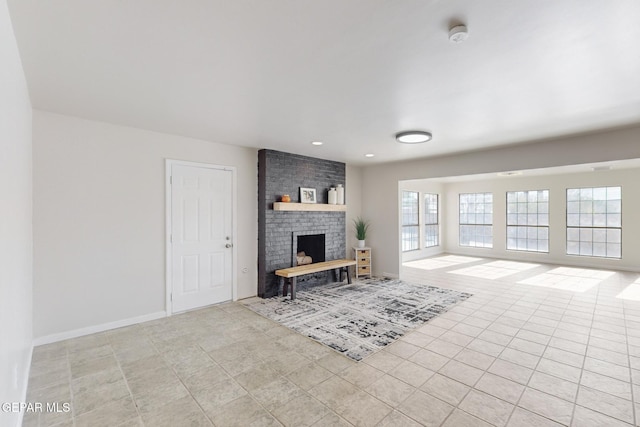 unfurnished living room with a wealth of natural light, a fireplace, and light tile patterned flooring