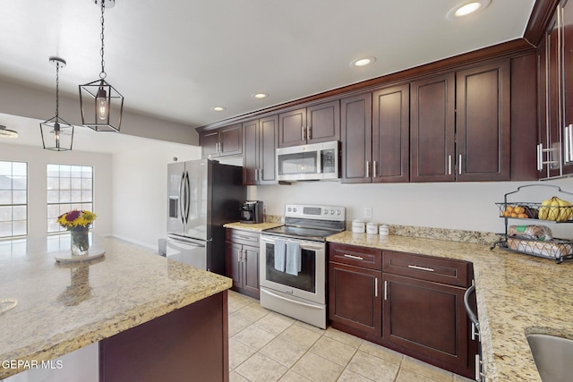 kitchen with light stone counters, light tile patterned floors, hanging light fixtures, and appliances with stainless steel finishes